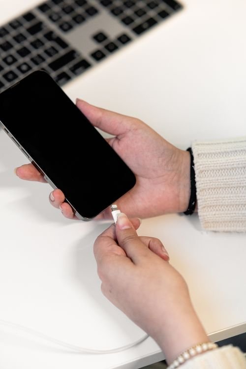 Smartphone plugged into a charging cable, a phone keeps restarting fix