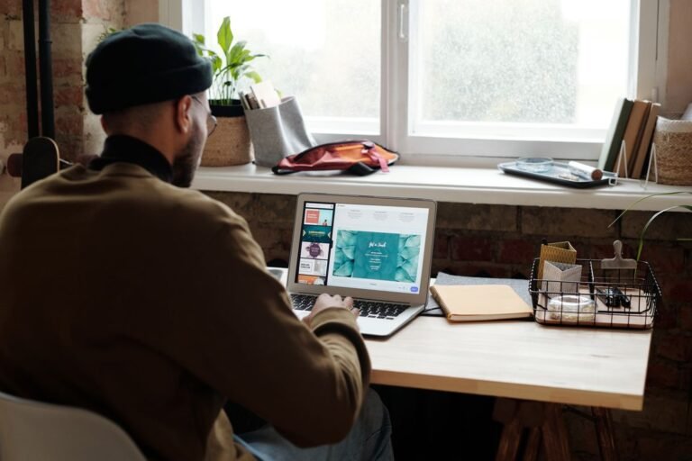 Man working remotely at home on a laptop by a window, a slow computer startup fix morning routine