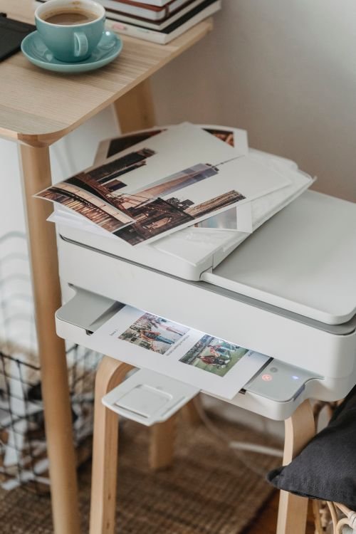 White printer with freshly printed pages in its output tray, a printer not printing fix.
