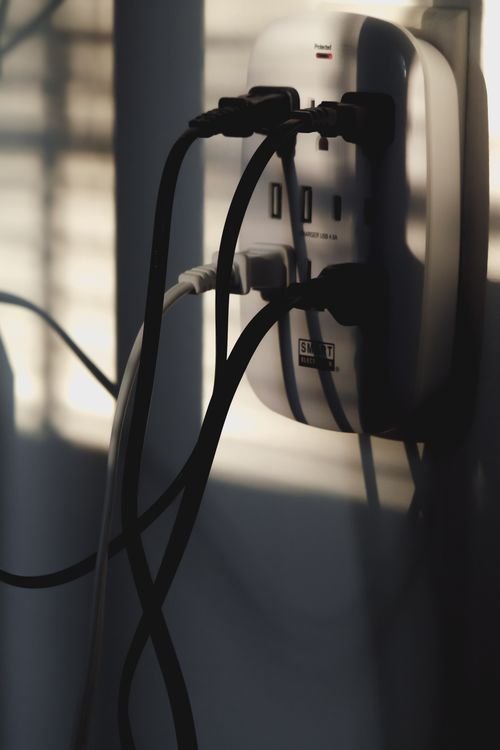 Multiple charging cables plugged into a wall outlet, showing a proper wall charger setup